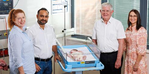 Fr Robert McCulloch, second right, and St Elizabeth’s administrator Eric Siraj meet Mater newborn Armani-Rose Richards with (left) and Mater Mothers’ Hospital general manager Kerri Gane (The Catholic Leader)