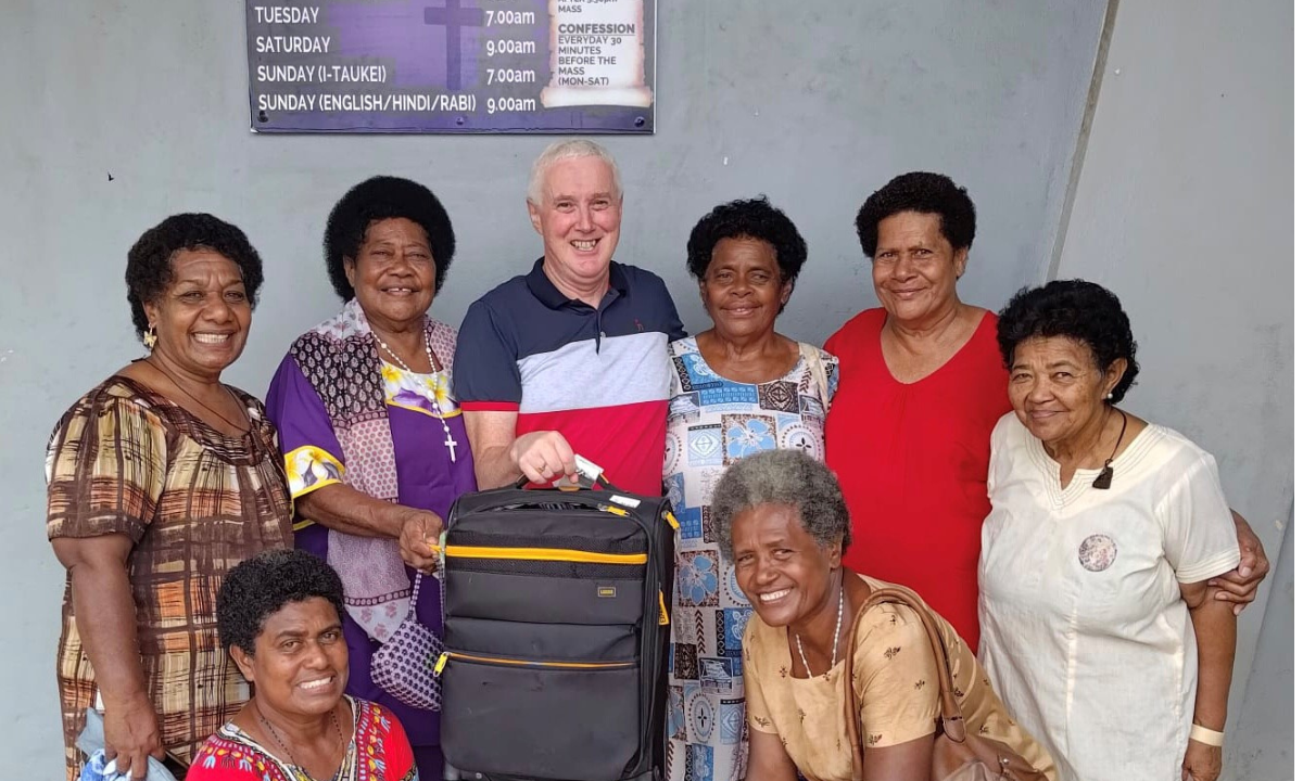Parishioners or Holy Family Parish Labasa with Fr. Tim Mulroy holding Fr. Charlie Dusters travel bag - Photo; Fr Tim Mulroy