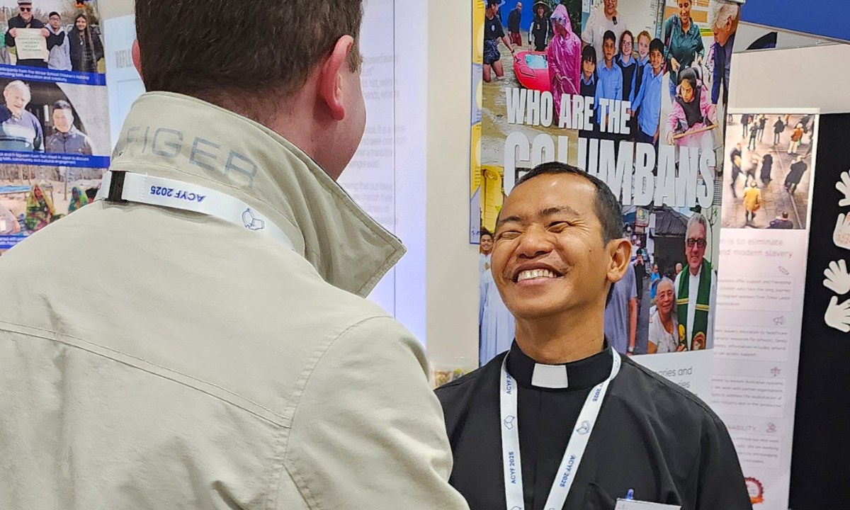 Fr La-Aung joyfully greets a pilgrim near the Columban Booth at the ACYF - Photo: Adi Mariana Waqa