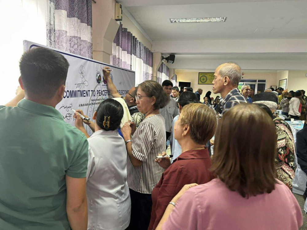 Participants of the dialogue sign their commitment to peaceful elections.