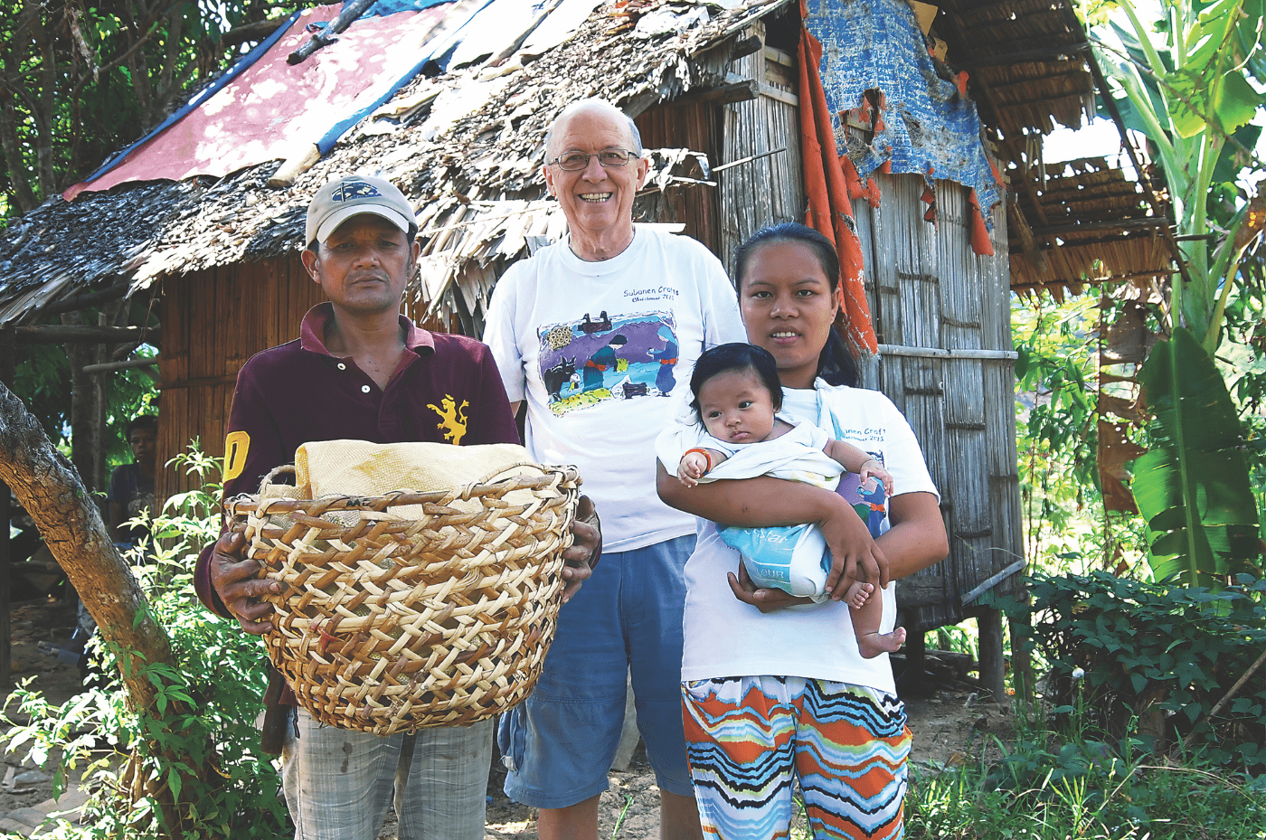 Fr. Vincent Busch with a Subanen couple and their child outside their home, which like baskets, they make from forest materials