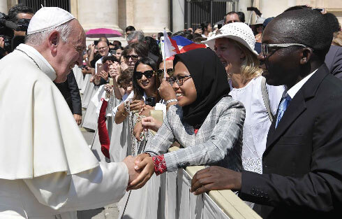 Pope Francis greeting a young Muslim girl, Dewi Kartika Maharani Praswida with Gus Durian, a youth movement affiliated with the world's largest moderate Islamic organisation in St Peter's Square. Photo: www.asianews.it