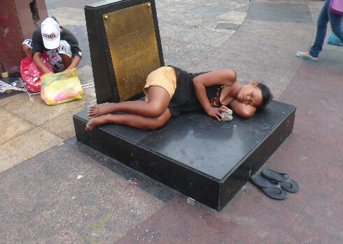 A woman sleeping in Manila’s Miranda Plaza neatly places her shoes outside the imagined entrance to the territory she has designated as her temporary home. Photo: Naanise Mo'unga CLM