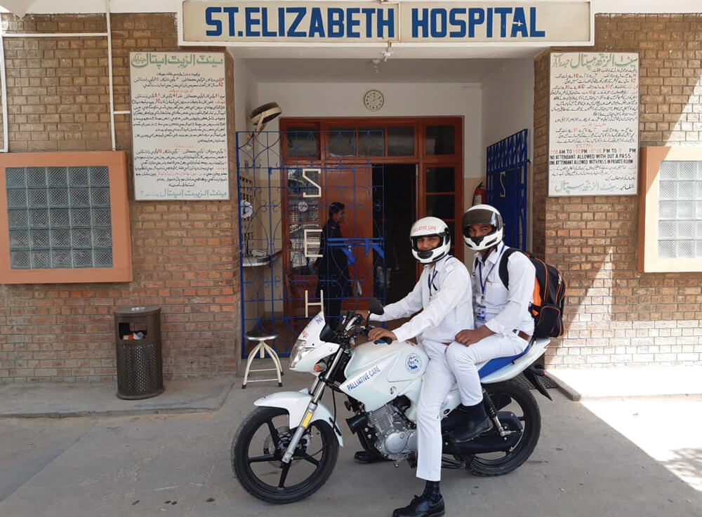 Two male nurses on the motorbike ambulance in front of St Elizabeth's Hospital in Hyderabad, Pakistan. Photo: Fr Robert McCulloch SSC