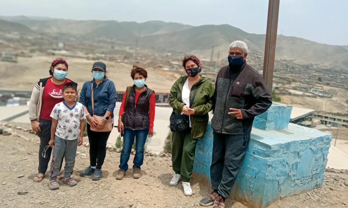 Columbans, Fr Iowane Gukibao (right) and lay missionary, Anna Flores (third from left), stand with a family on the dry earth of Lima, Peru. - Photo:Ana Flores