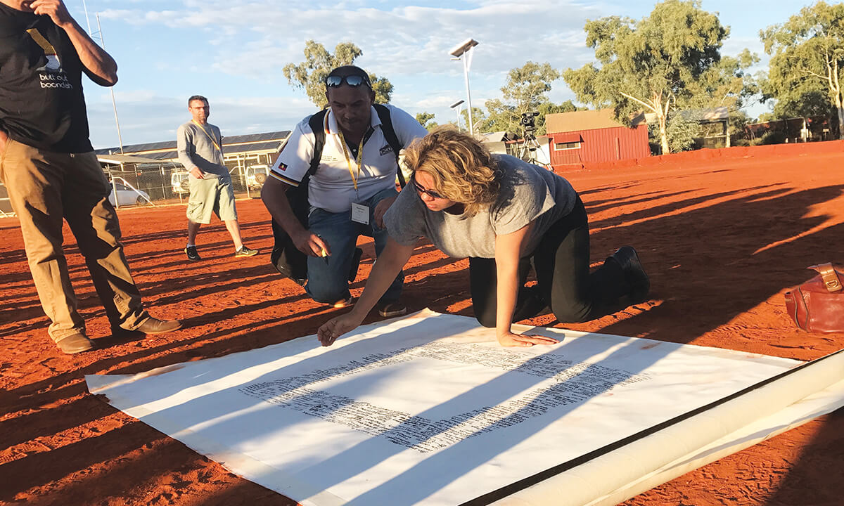 Denise Bowden, the chief executive of Yothu Yindi, signing the Uluru Statement from the Heart in Central Australia. Photo: Australian Human Rights Commission (https://commons.wikimedia.org/wiki/File:Denise_Bowden_Yothu_Yindi_CEO_signing_the_Uluru_statement.jpg), https://creativecommons.org/licenses/by/2.0/legalcode