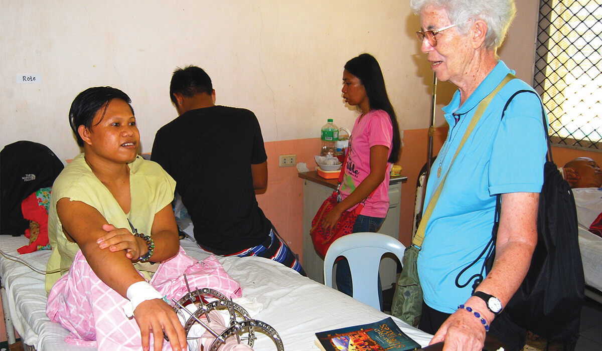 Jemuel with Columban Sr Kathleen Melia in the hospital after his leg operation. - Photo: Fr Vincent Busch SSC