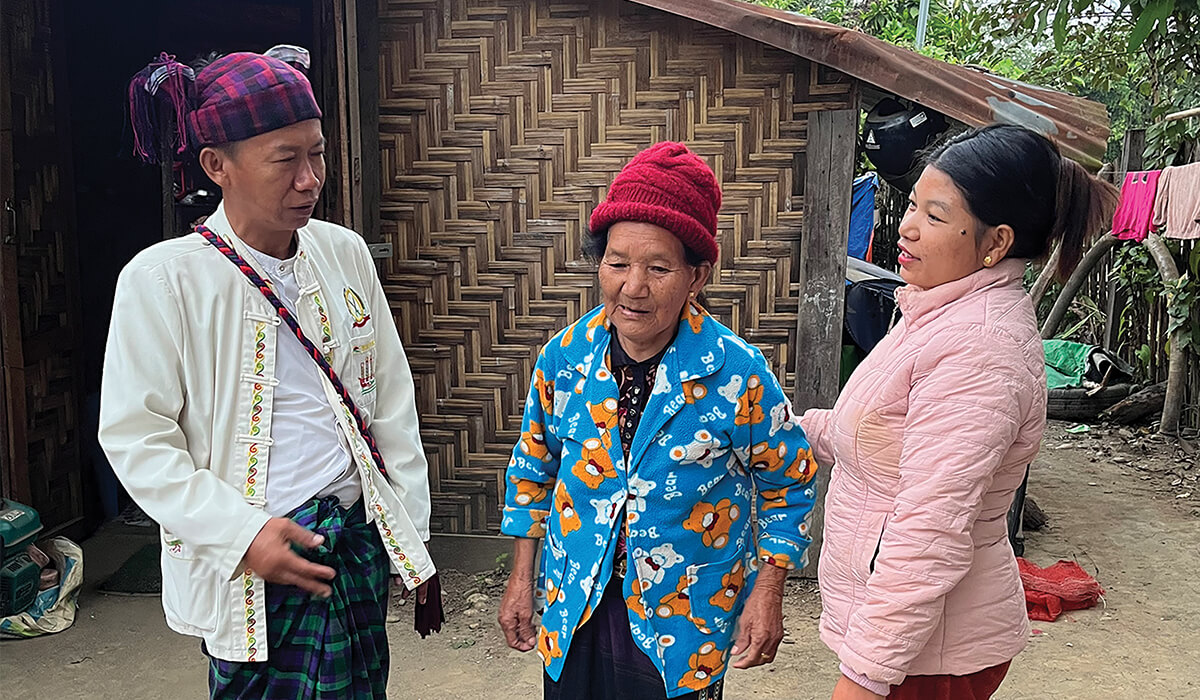 Udi Lu, an elderly Kachin Catholic, and her granddaughter, in conversation with Kachin catechist. - Photo: St Columbans Mission Society