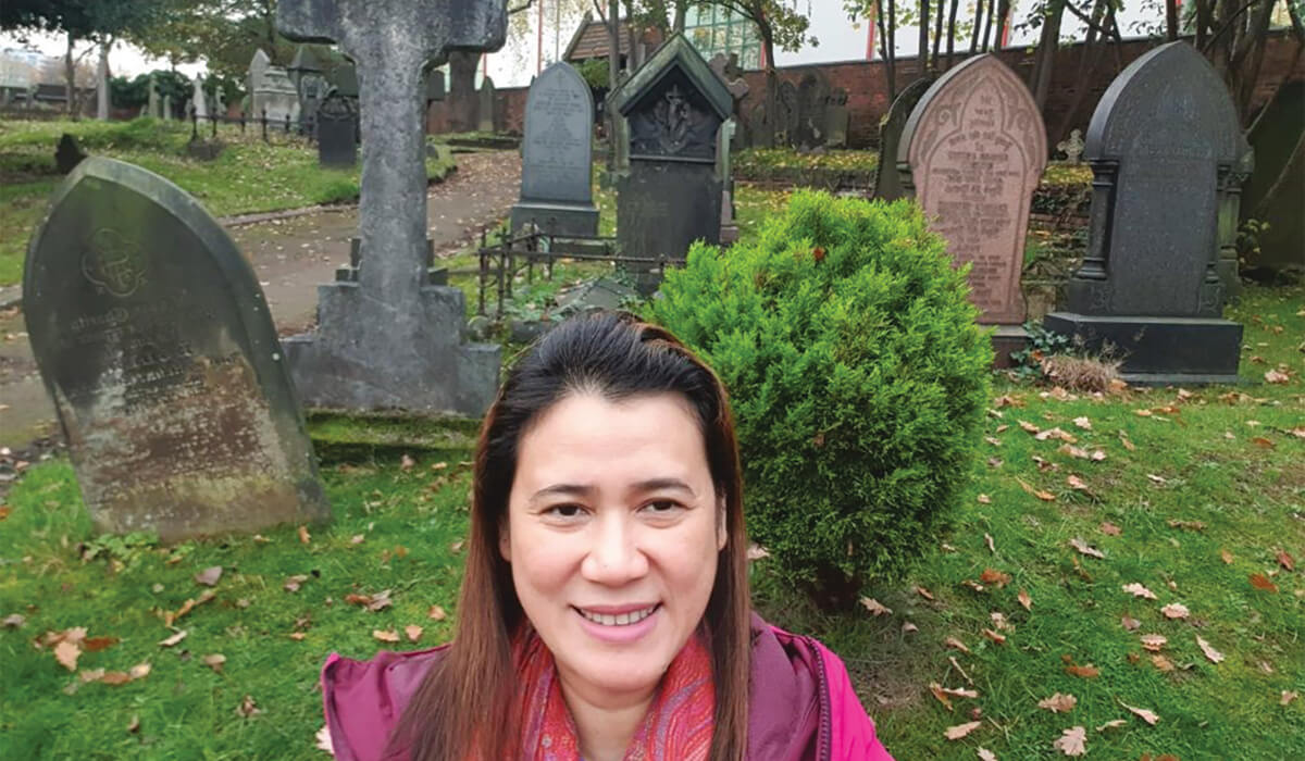 Columban lay missionary, Gertrudes Samsom standing in front of the tombstones that surround the house. - Photo: Gertrudes Samsom