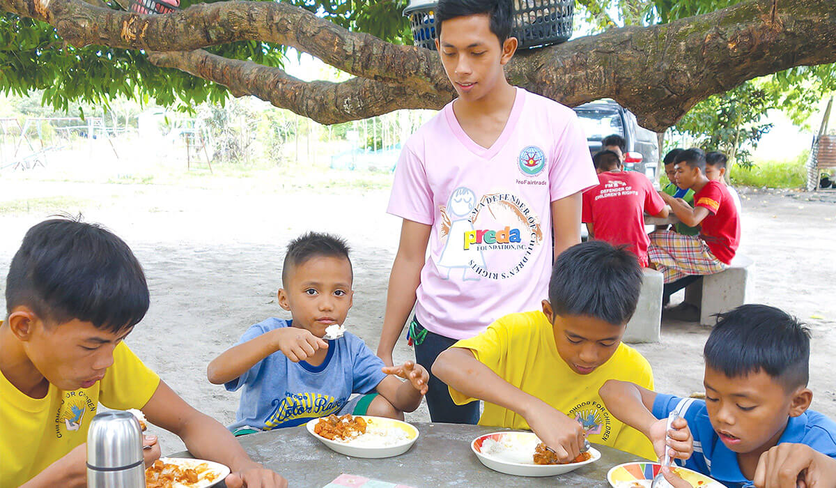Students at the PREDA Youth home enjoying a meal watched on by the caring eye of their teacher - Photo: Fr Shay Cullen