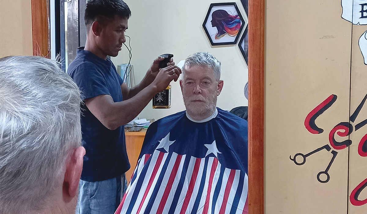 Columban Fr Eamon Sheridan receiving a haircut by an after-care client from the Vocational Training Programme in Myanmar. Photo: Fr Eamon Sheridan SSC