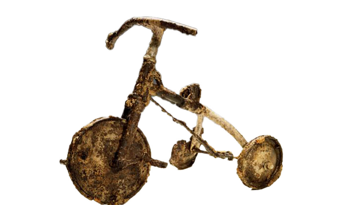 The small child’s tricycle, burnt and twisted. Photo: Fr Barry Cairns SSC