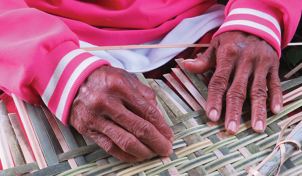 Calloused hands transform strands of bamboo and rattan into a work of art disguised as an ordinary basket. Photo: Fr Vincent Busch SSC